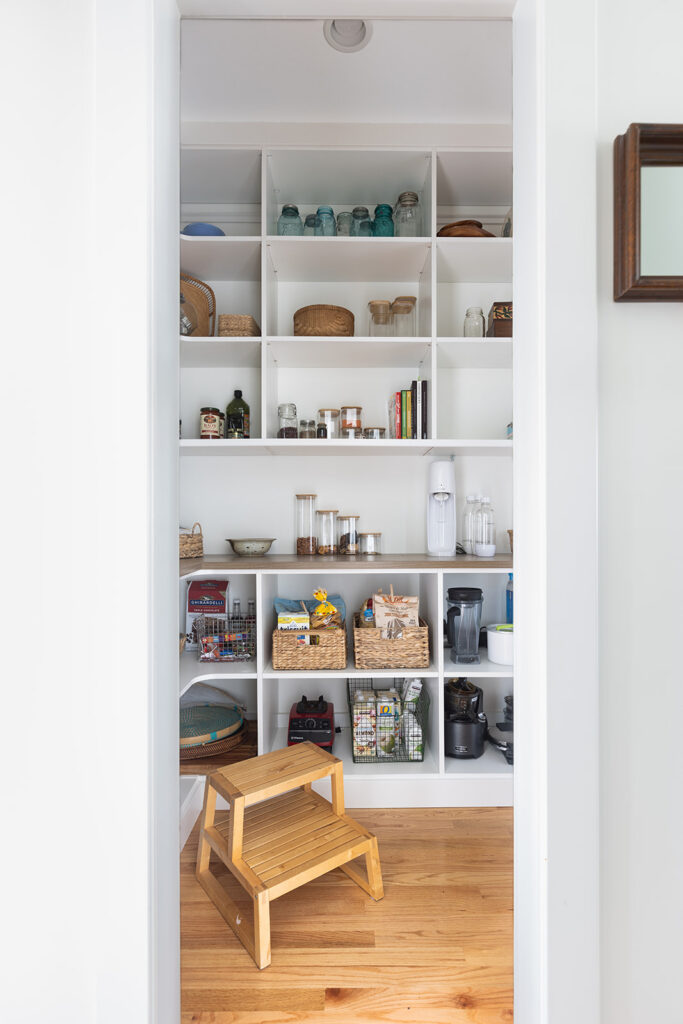 Walk-in pantry with custom open shelving and organized storage in Fairfax VA kitchen remodel featuring functional pantry design, natural wood finishes, and convenient access from the main kitchen.