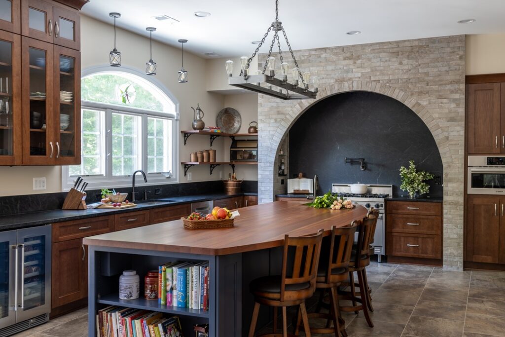 Overall view of a luxury Clifton, VA kitchen remodel showcasing Showplace cabinetry in Hale Navy on the island and Cherry Pecan perimeter cabinets, paired with Virginia Mist honed granite and warm wood accents for a refined, entertainer-focused design.